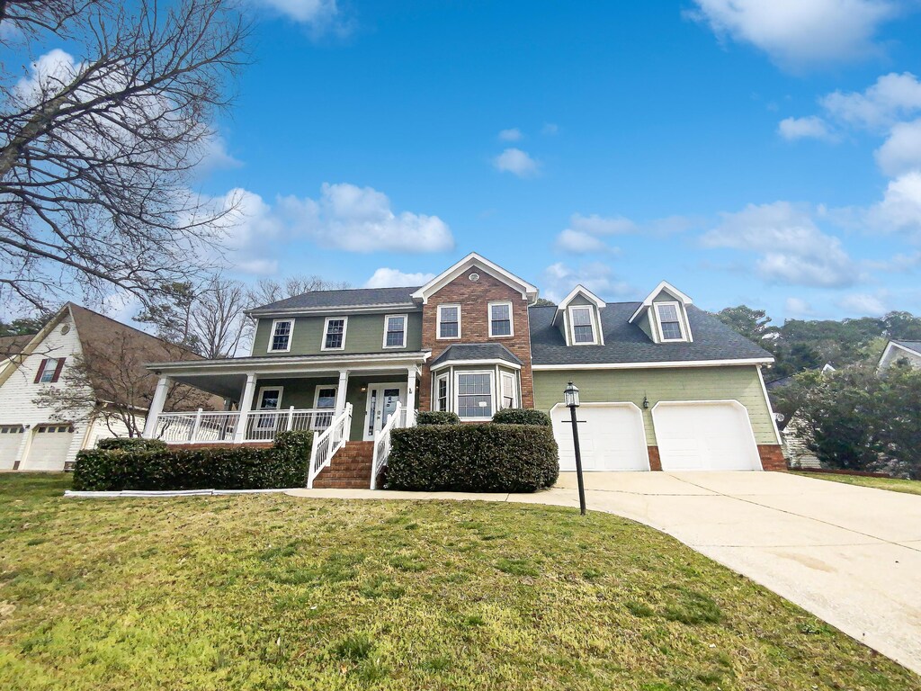89 Autumn Dr, Ringgold, GA 30736 - view of front of home with driveway, covered porch, a front lawn, a garage, and brick siding