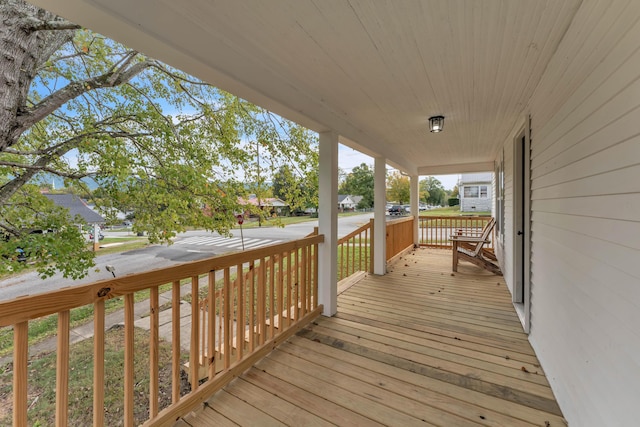 wooden deck with a residential view and covered porch