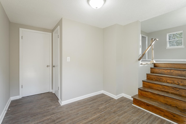 stairs with hardwood / wood-style floors and a textured ceiling