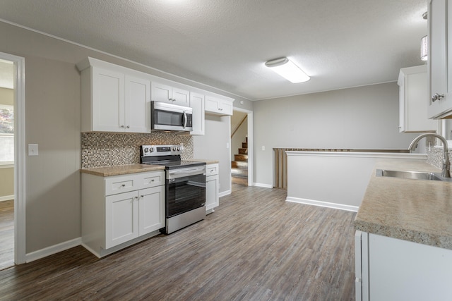 kitchen featuring sink, a textured ceiling, dark hardwood / wood-style flooring, stainless steel appliances, and white cabinets