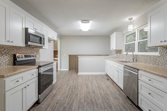 kitchen featuring stainless steel appliances, sink, and white cabinets