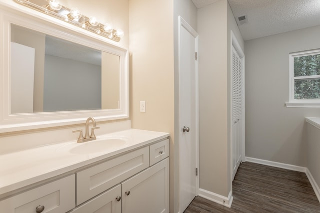 bathroom with vanity, hardwood / wood-style flooring, and a textured ceiling