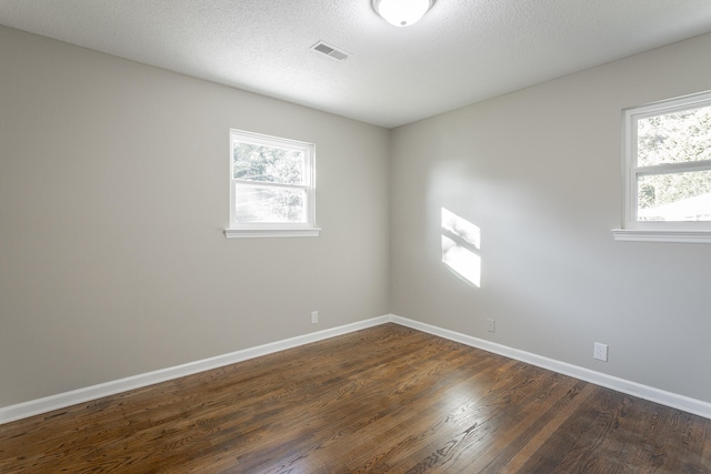 empty room featuring dark wood-type flooring and a textured ceiling