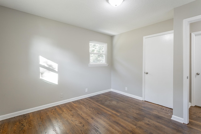 unfurnished bedroom featuring dark hardwood / wood-style floors and a textured ceiling