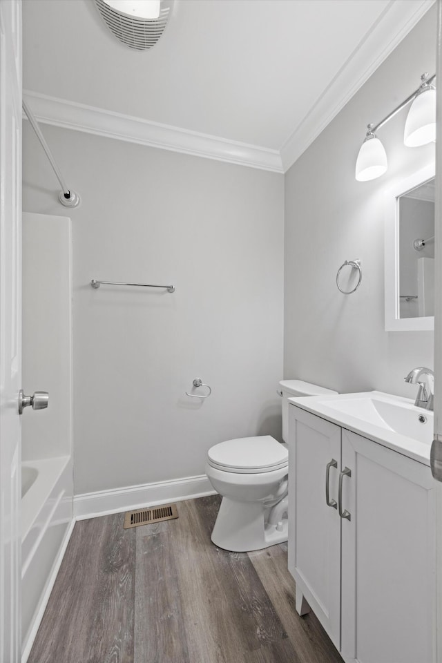 full bathroom with toilet, shower / bathing tub combination, ornamental molding, hardwood / wood-style floors, and vanity