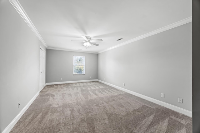 spare room featuring ornamental molding, carpet, and ceiling fan