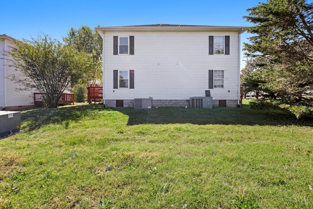 view of side of home with central AC and a lawn