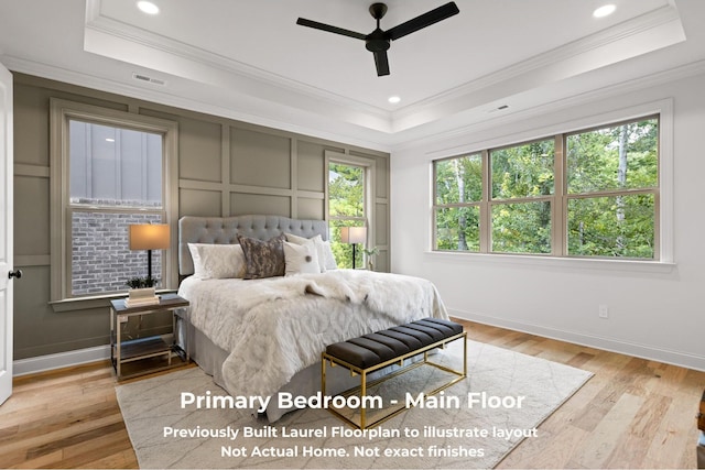 bedroom with a raised ceiling, crown molding, ceiling fan, and light wood-type flooring