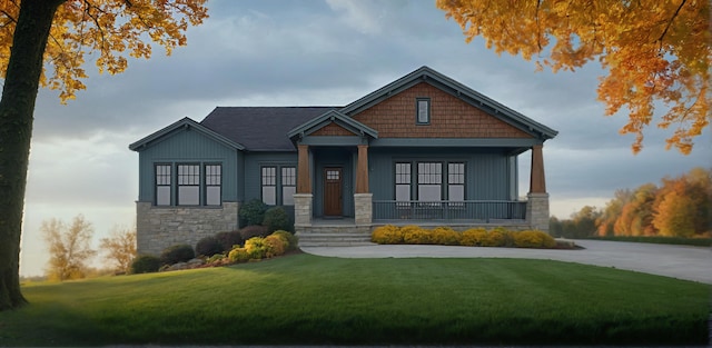 craftsman-style home featuring covered porch and a front yard