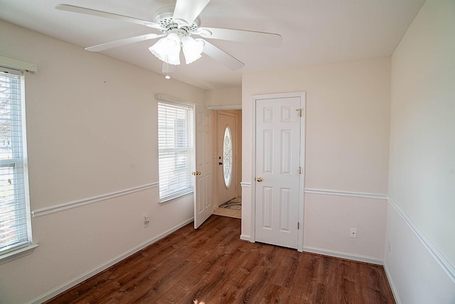 empty room with ceiling fan and dark wood-type flooring