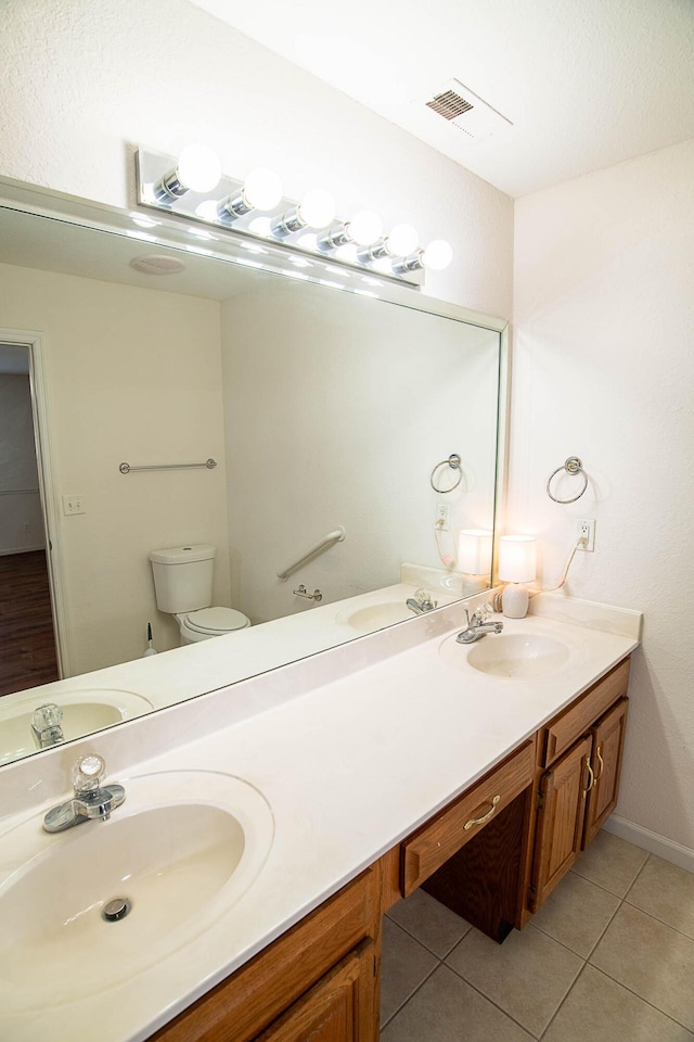 bathroom with tile patterned flooring, vanity, and toilet