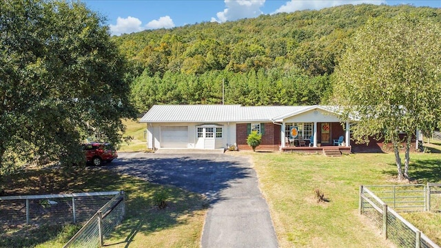 ranch-style house with a front yard, a porch, and a garage