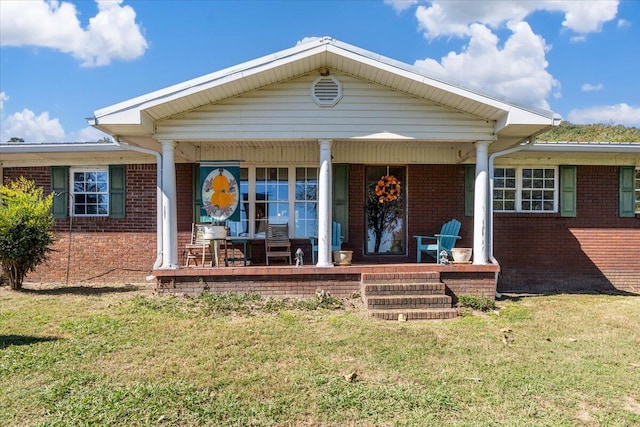 back of house featuring covered porch and a lawn