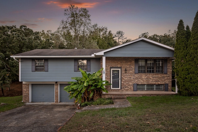 raised ranch featuring a yard and a garage