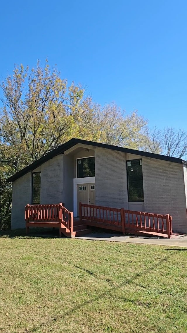 view of front of home with a deck and a front yard