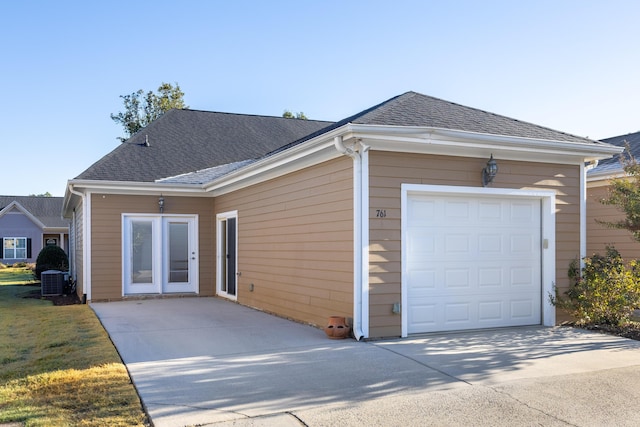 back of property featuring cooling unit and a garage