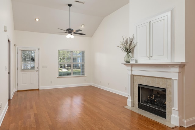 unfurnished living room with light hardwood / wood-style flooring, high vaulted ceiling, a fireplace, and ceiling fan