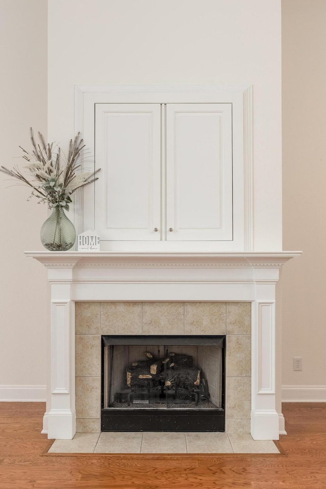 room details featuring a tile fireplace and hardwood / wood-style floors