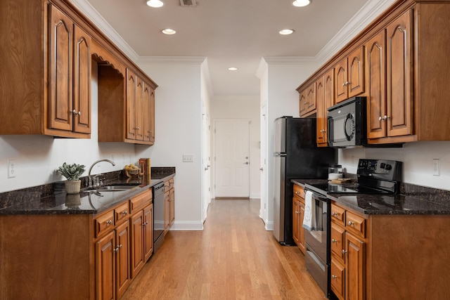 kitchen featuring crown molding, appliances with stainless steel finishes, sink, and light wood-type flooring