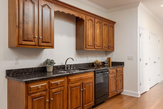 kitchen with dark stone counters, light hardwood / wood-style flooring, ornamental molding, dishwasher, and sink