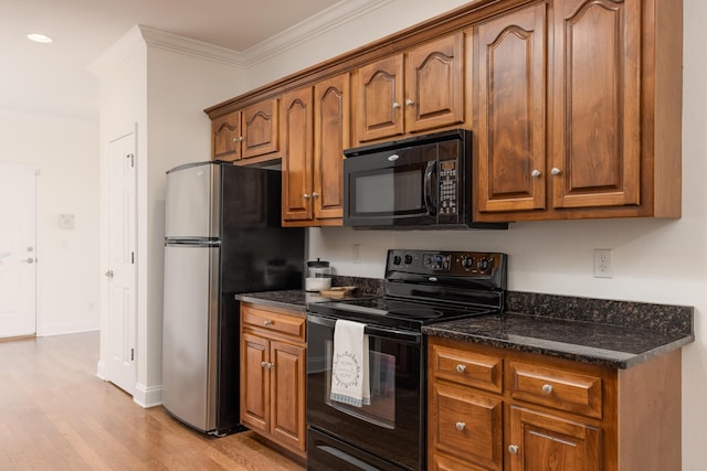 kitchen featuring light hardwood / wood-style floors, black appliances, ornamental molding, and dark stone counters