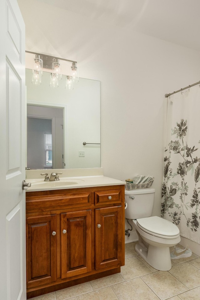 bathroom featuring toilet, vanity, tile patterned floors, and a shower with shower curtain