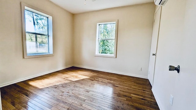 empty room with a wealth of natural light, a wall unit AC, dark hardwood / wood-style floors, and ceiling fan