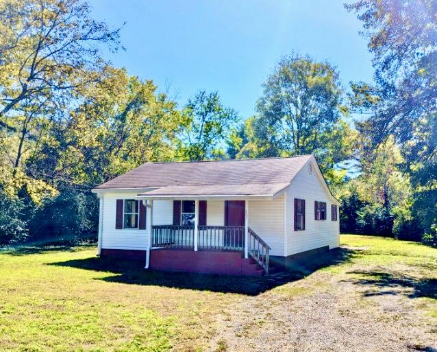 view of front of home with a porch and a front lawn