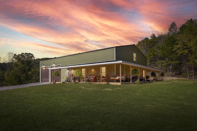 exterior space with covered porch, a lawn, and a garage