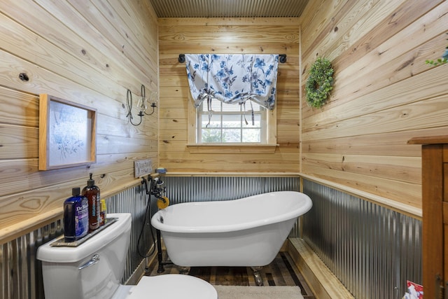 bathroom with toilet, a bathing tub, and wooden walls