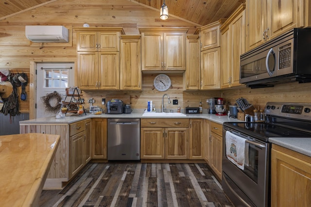 kitchen with a wall unit AC, appliances with stainless steel finishes, vaulted ceiling, sink, and wooden walls