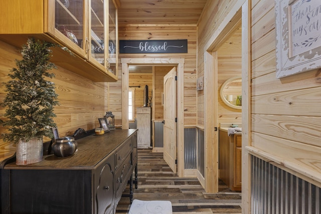 corridor with wood walls and dark hardwood / wood-style floors