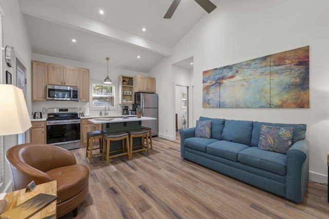 living room featuring beam ceiling, ceiling fan, sink, high vaulted ceiling, and light wood-type flooring