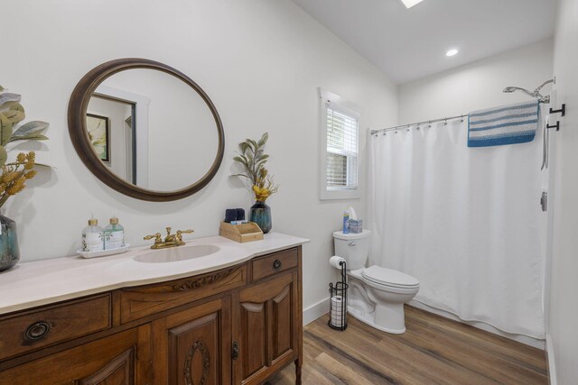 bathroom featuring toilet, recessed lighting, wood finished floors, and vanity