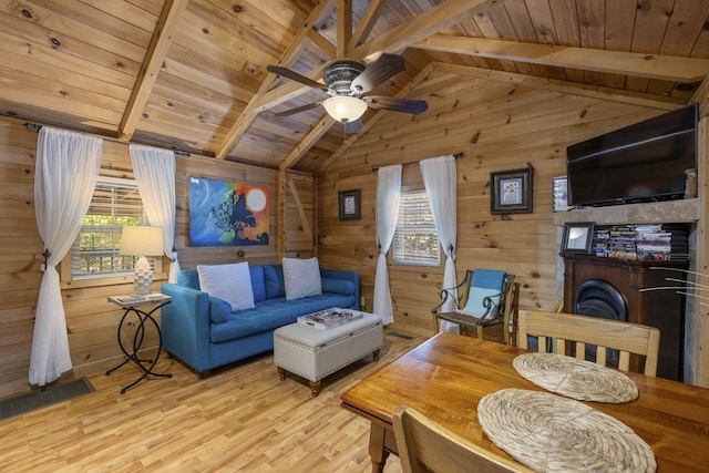 living area with wood ceiling, wood walls, light wood-style flooring, and lofted ceiling with beams