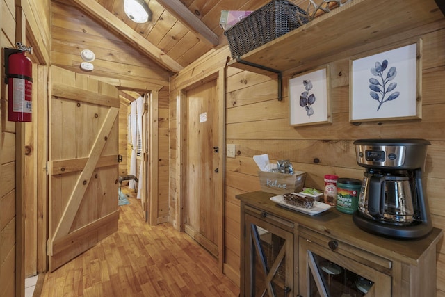 hall featuring wooden ceiling, wood walls, light wood-style floors, and lofted ceiling