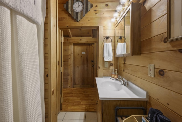 bathroom featuring tile patterned floors, vanity, and wood walls