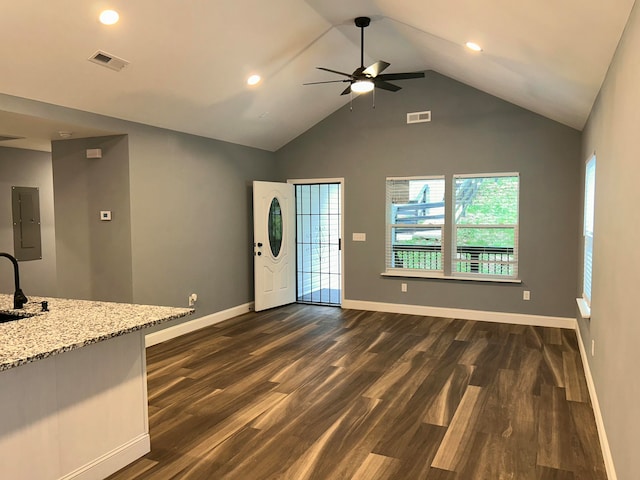 unfurnished living room featuring ceiling fan, sink, dark hardwood / wood-style flooring, electric panel, and vaulted ceiling