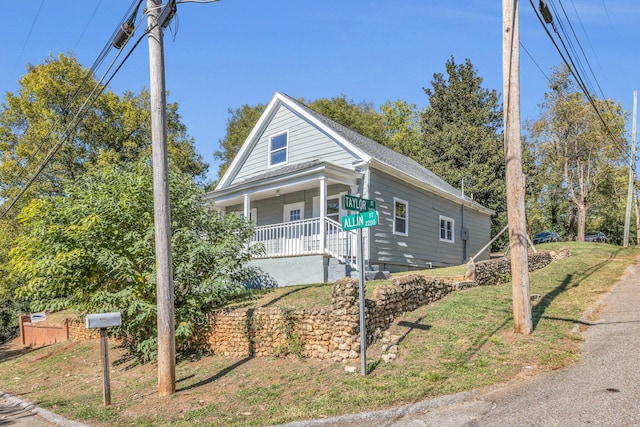 view of front of property with a porch and a front lawn