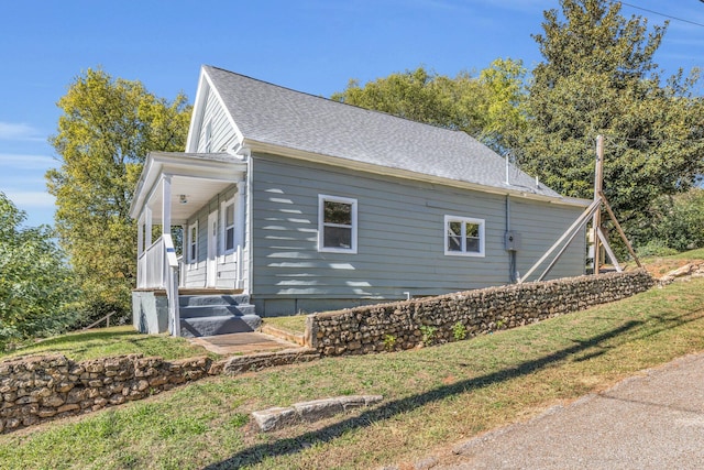 view of home's exterior with a yard and covered porch