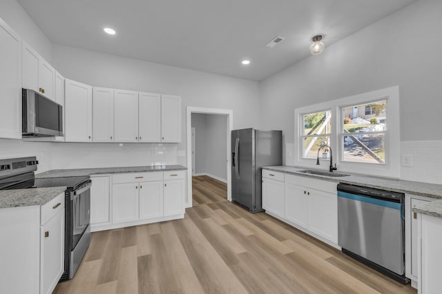 kitchen with white cabinets, appliances with stainless steel finishes, and sink