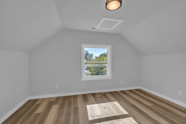 additional living space featuring wood-type flooring and vaulted ceiling