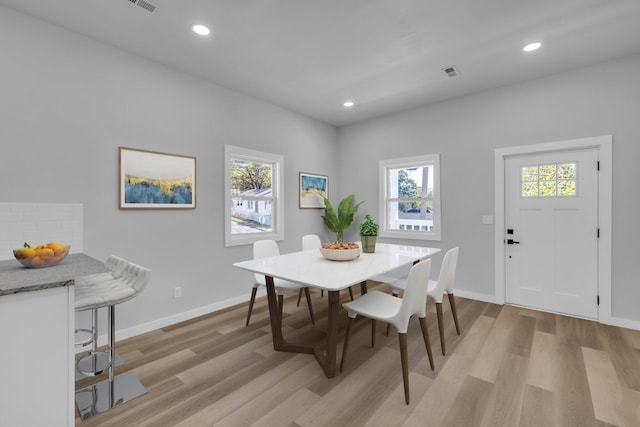 dining area with light wood-type flooring and a wealth of natural light