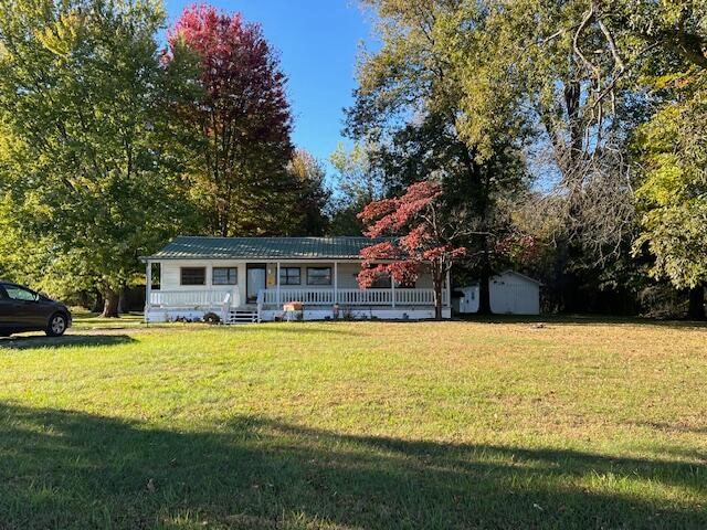 ranch-style home with a front yard and an outbuilding