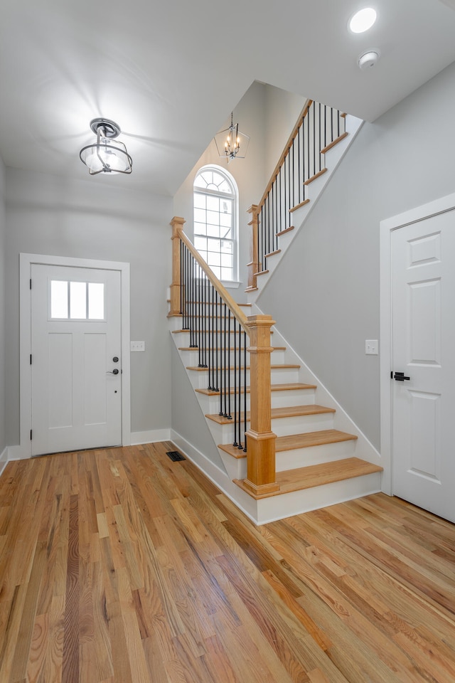 entrance foyer with light wood-type flooring and a chandelier