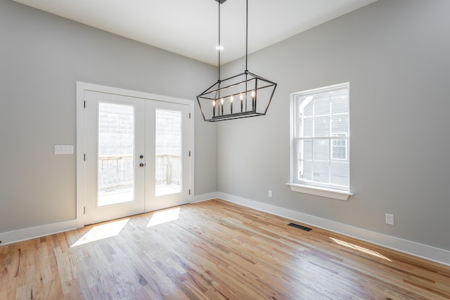 unfurnished dining area featuring plenty of natural light, light hardwood / wood-style flooring, and french doors