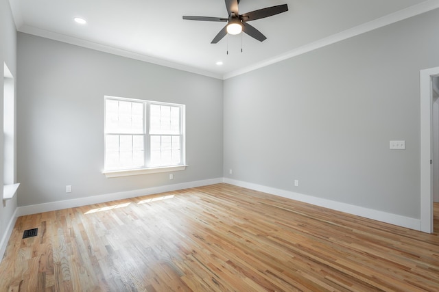 spare room featuring a ceiling fan, visible vents, crown molding, baseboards, and light wood-style flooring