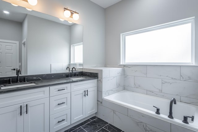 bathroom featuring vanity and tiled tub