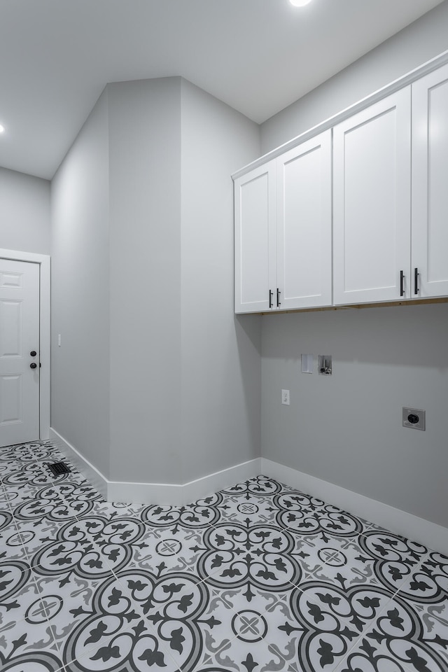 clothes washing area featuring hookup for an electric dryer and cabinets