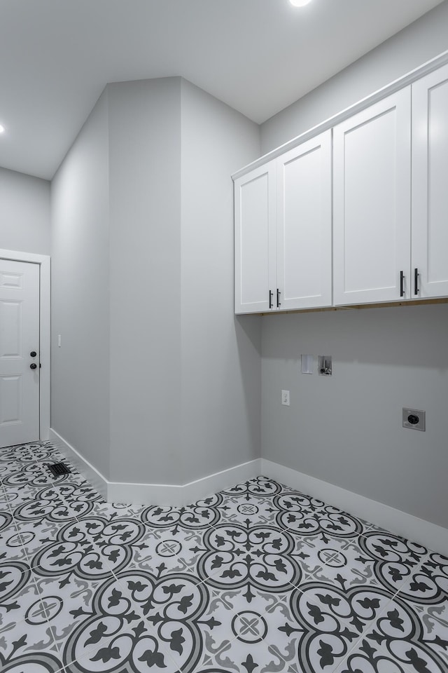 washroom featuring baseboards, cabinet space, tile patterned flooring, and hookup for an electric dryer